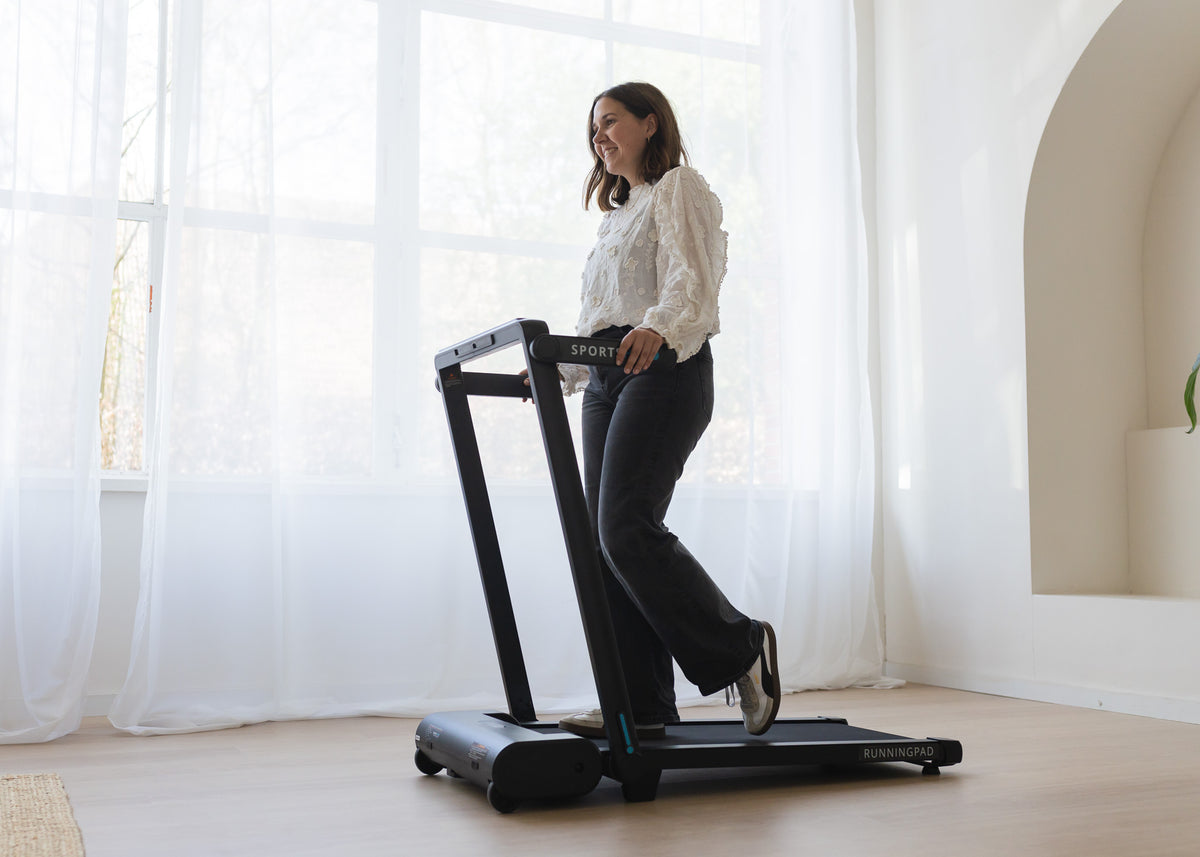 Sanne marche sur son RunningPad Pro devant la fenêtre